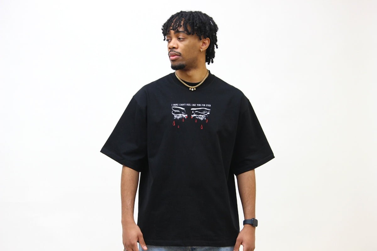 T-shirt oversize noir en coton bio porté par un homme - We Got Pain